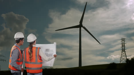 Animation-Einer-Sich-Drehenden-Windturbine,-Männliche-Und-Weibliche-Ingenieure-Lesen-Pläne-Mit-Landschaft