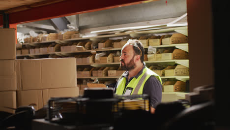 Caucasian-male-factory-worker-at-a-factory-standing-in-a-workshop,-counting,-inspecting