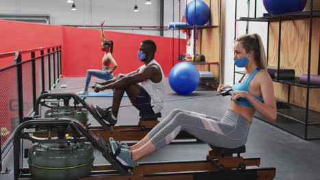 Eine-Heterogene-Gruppe-Mit-Gesichtsmasken-Trainiert-Im-Fitnessstudio