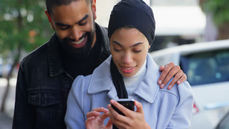 Couple-using-mobile-phone-on-street-4k