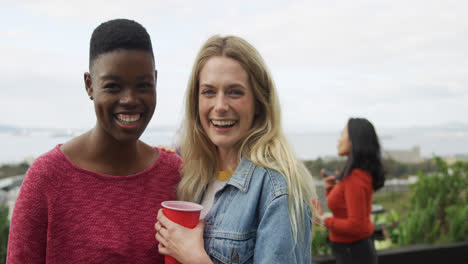 Young-women-smiling-at-camera-on-a-rooftop