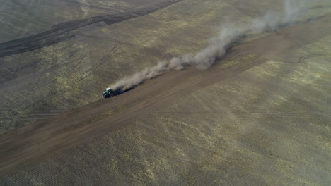 Aerial-view-of-tractor-moving-on-harvested-field-4k