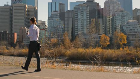 Side-view-of-young-Caucasian-man-using-mobile-phone-while-walking-on-road-in-city-4k