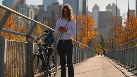 Vorderansicht-Eines-Jungen-Kaukasischen-Mannes,-Der-Auf-Der-Brücke-Ein-Mobiltelefon-Benutzt-4k