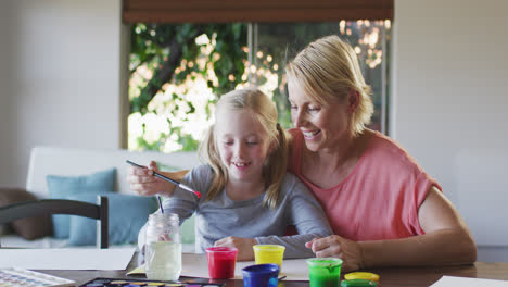 Caucasian-woman-painting-with-her-daughter-at-home