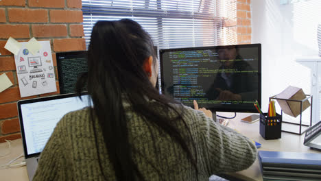 Female-executive-working-on-computer-while-using-laptop-in-office-4k