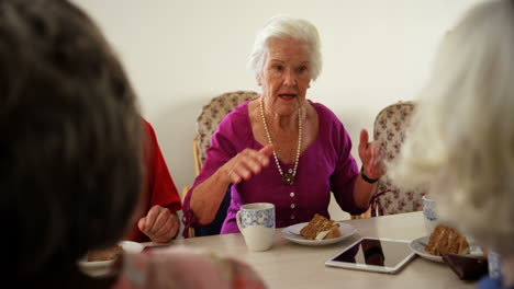 Group-of-Mixed-race-senior-friends-eating-breakfast-on-dining-table-4k