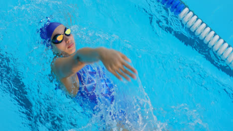 Young-female-swimmer-swimming-inside-pool-4k