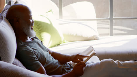 Hombre-Mayor-Leyendo-Un-Libro-En-La-Sala-De-Estar-4k