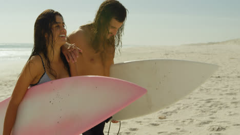 Pareja-Con-Tabla-De-Surf-Caminando-Por-La-Playa-4k-4k