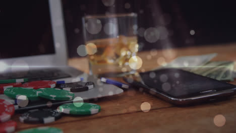 Wooden-table-with-glass-of-whisky,-banknotes,-gambling-chips,-computer,-mobile-phone-and-animated-bu