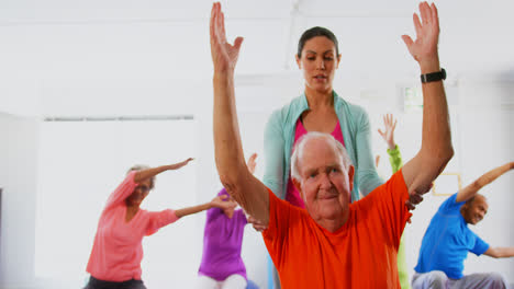 Vista-Frontal-De-Una-Entrenadora-Caucásica-Entrenando-A-Un-Hombre-Mayor-En-Ejercicio-En-El-Gimnasio-4k