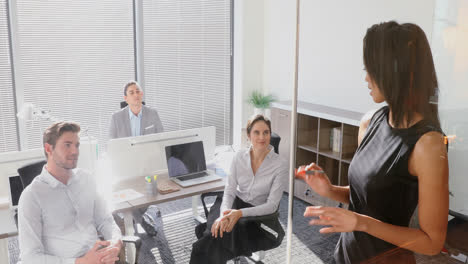 Female-executive-with-his-colleagues-discussing-over-glass-board-4k