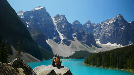 Couple-sitting-on-a-rock-near-riverside-4k