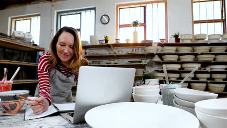 Female-potter-checking-the-orders-from-laptop-4k