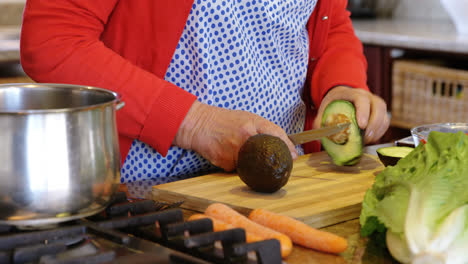 Senior-woman-chopping-vegetable-in-kitchen-at-home-4k