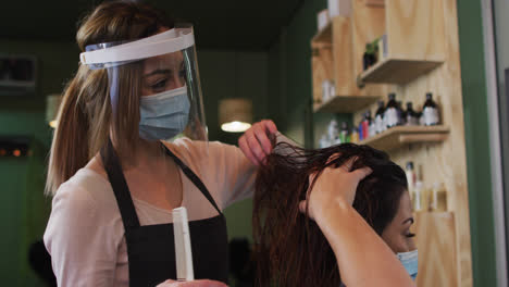 Friseurin-Mit-Gesichtsbedeckung-Kämmt-Die-Haare-Einer-Kundin-Im-Friseursalon