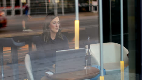 Front-view-of-beautiful-caucasian-businesswoman-working-on-laptop-in-a-modern-hotel-4k