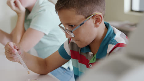 Girl-wearing-glasses-using-pipette-and-beaker