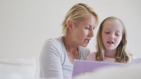 Vista-De-ángulo-Bajo-De-Una-Mujer-Caucásica-Leyendo-Un-Cuento-A-Su-Hija