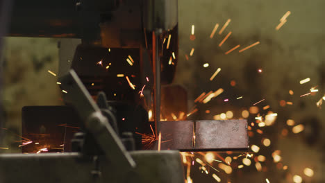 Detail-of-a-Caucasian-male-factory-worker-at-a-factory-standing-at-a-workbench-and-cutting-a-metal-