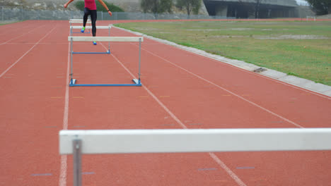 Atleta-Caucásica-Corriendo-Sobre-Obstáculos-En-Una-Pista-De-Atletismo-En-Un-Recinto-Deportivo-4k