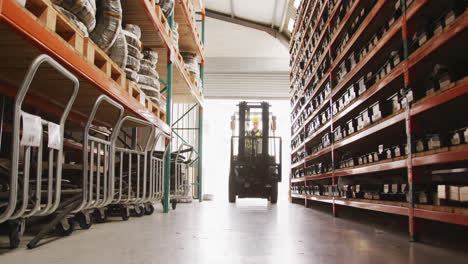 Caucasian-male-factory-worker-at-a-factory-with-a-hat-and-high-vis-vest,-using-a-truck