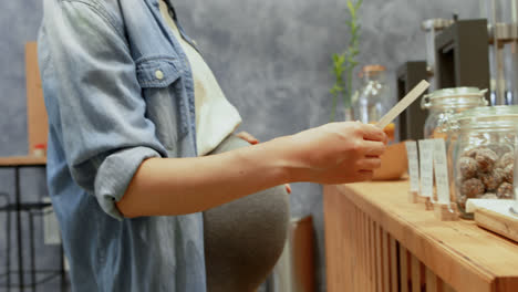 Pregnant-woman-standing-at-counter-4k