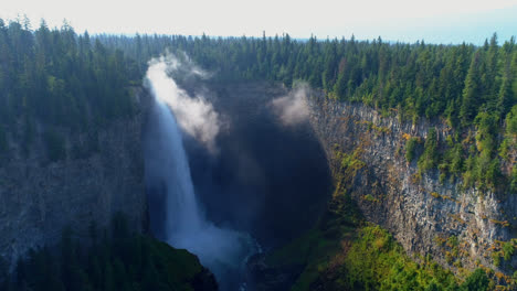 Beautiful-water-fall-through-forest-cliff-on-a-sunny-day-4k