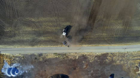 Aerial-view-of-tractor-moving-on-harvested-field-4k