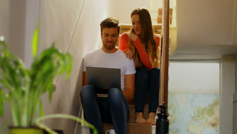 Couple-discussing-over-laptop-on-staircase-4k