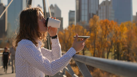 Side-view-of-young-Caucasian-man-on-bridge-talking-on-mobile-phone-4k