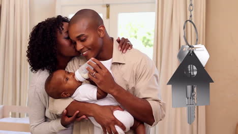 House-keys-and-key-fob-hanging-with-couple-with-baby-in-new-home-in-the-background