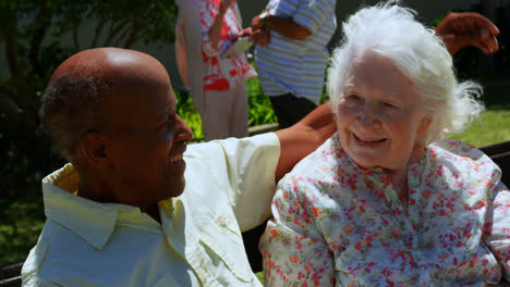 Vista-Frontal-De-Una-Pareja-Activa-De-Ancianos-De-Raza-Mixta-Abrazándose-En-El-Jardín-De-Una-Residencia-De-Ancianos-4k