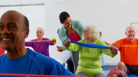 Vista-Frontal-De-Una-Entrenadora-Caucásica-Entrenando-A-Una-Mujer-Mayor-En-Ejercicio-En-El-Gimnasio-4k