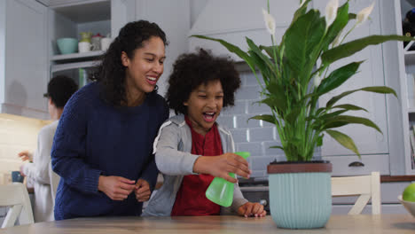 Pareja-De-Lesbianas-De-Raza-Mixta-E-Hija-Regar-Las-Plantas-En-La-Cocina