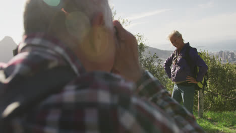 Senior-man-taking-picture-of-senior-woman-on-mountains