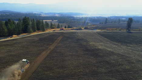 Aerial-view-of-tractor-moving-on-harvested-field-4k