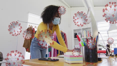 Animation-of-floaing-covid-19-cells-with-woman-in-office-wearing-face-masks