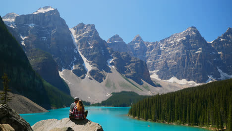 Couple-sitting-on-a-rock-near-riverside-4k