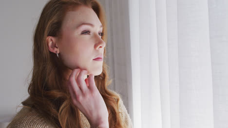 Woman-looking-out-of-the-window-at-home