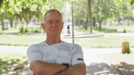 Senior-man-standing-with-his-arms-crossed-in-the-park