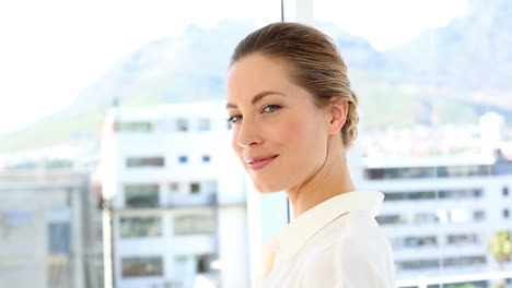 Pretty-businesswoman-drinking-cup-of-coffee-smiling-at-camera