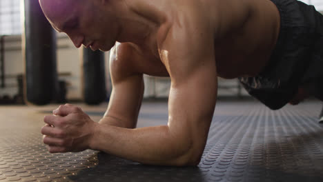 Caucasian-muscular-shirtless-bald-man-exercising-and-doing-plank