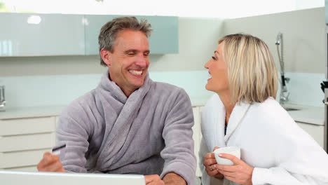 Mature-happy-couple-shopping-online-at-breakfast