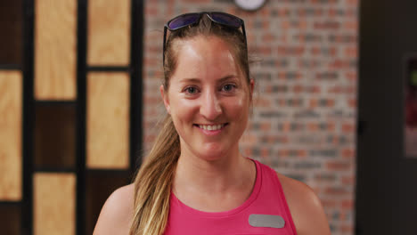 Portrait-of-caucasian-woman-with-sunglasses-on-her-head-smiling-to-camera