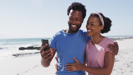 Pareja-Afroamericana-Sonriendo-Tomando-Selfie-Con-Teléfono-Inteligente-En-La-Playa