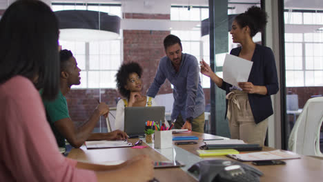 Mixed-race-business-colleagues-sitting-having-a-discussion-in-meeting-room