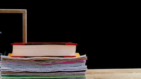 Chemistry-and-science-concept-icons-against-back-to-school-text-on-wooden-slate-and-stack-of-books