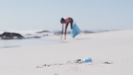 Mujer-Afroamericana-Vistiendo-Sacos-De-Basura-Y-Recogiendo-Basura-De-La-Playa